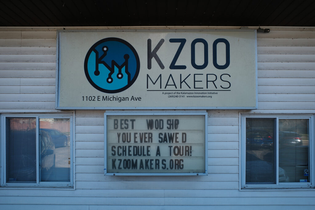 Kalamazoo Makers front sign with caption “a project of the kalamazoo innovation initiative” and “the best woodshop you ever sawed, schedule a tour kzoomakers.org”