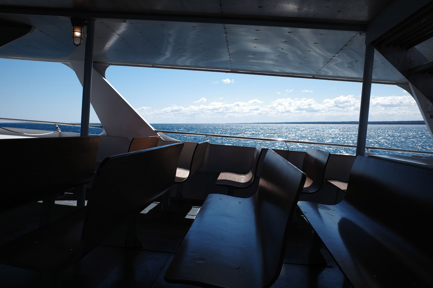 Benches and view of lake from inside the Mackinac Island Ferry.