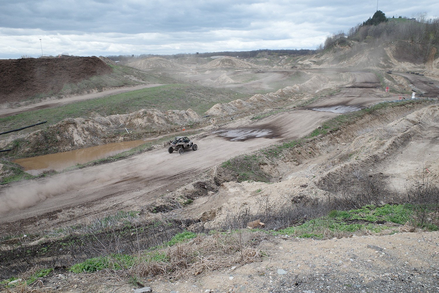 Off road vehicle traversing a trail in a large outdoor recreational vehicle park.