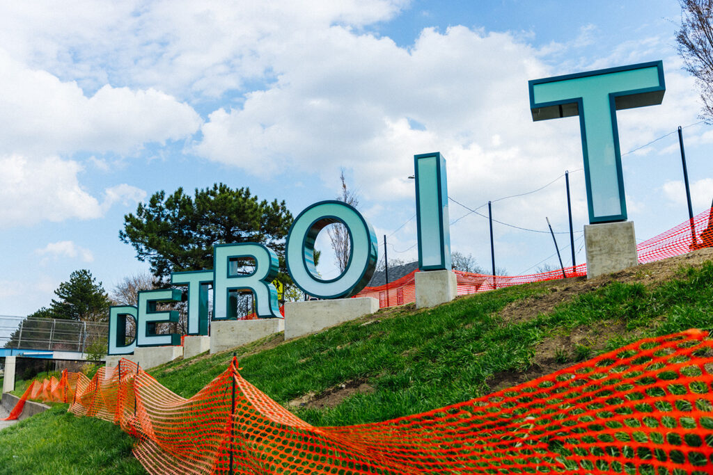 Detroit sign reminiscent of the famous Hollywood sign on the side of the highway.