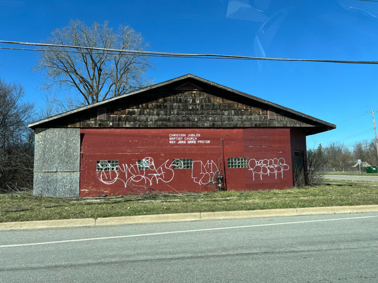 Abandoned building with graffiti, text reading “Christian Jubilee Baptist Church, Rev. Jake Hare Pastor”