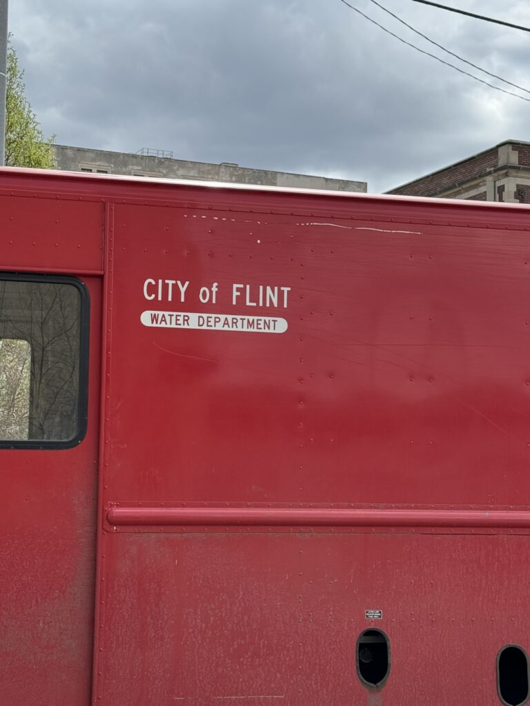 Red truck with label reading “City of Flint Water Department.”
