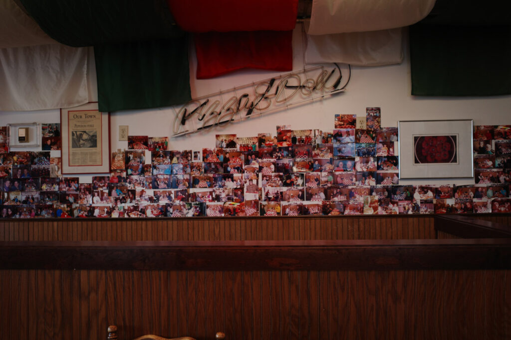 Dozens of old photographs pasted onto the wall of Paesano’s restaurant.
