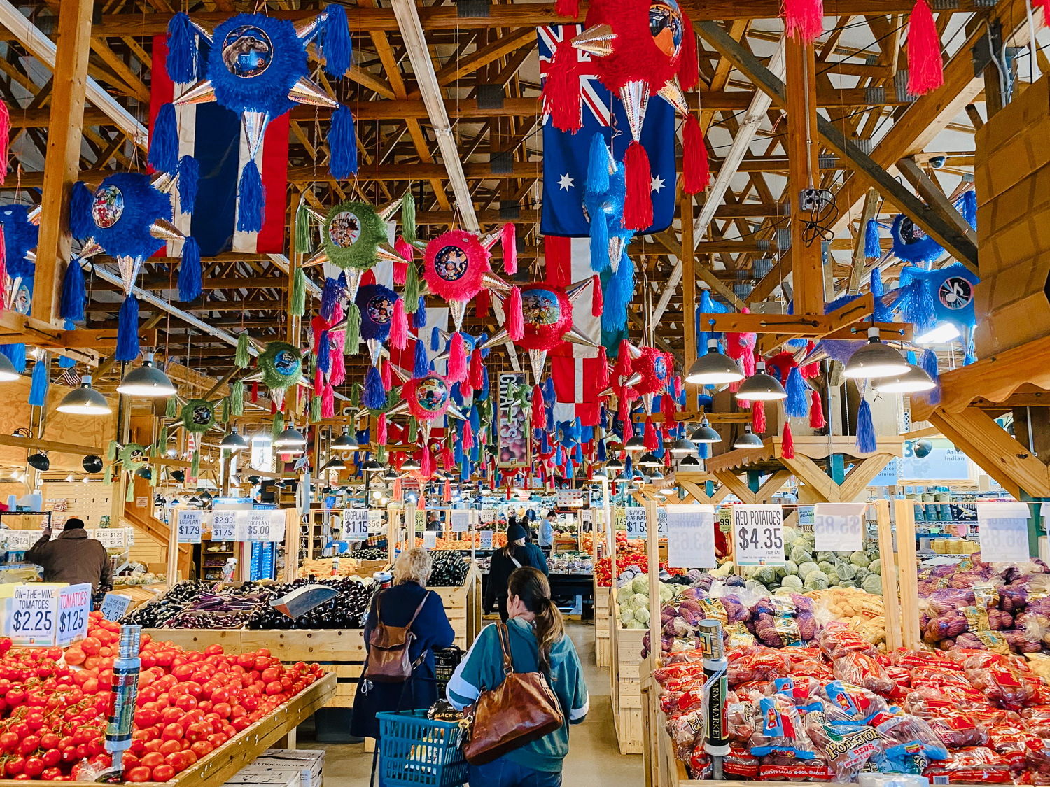 Inside of Horrocks grocery store with produce for sale and various signs listing type and price of produce.