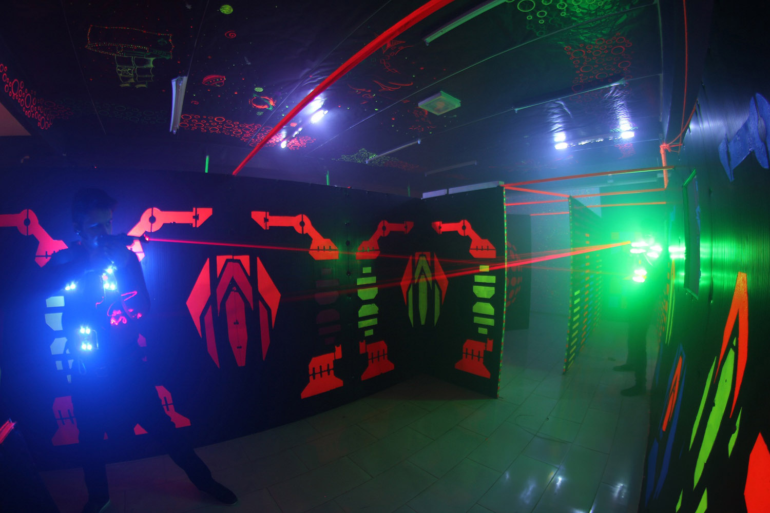 Interior of laser tag arena with fog and colored lights.