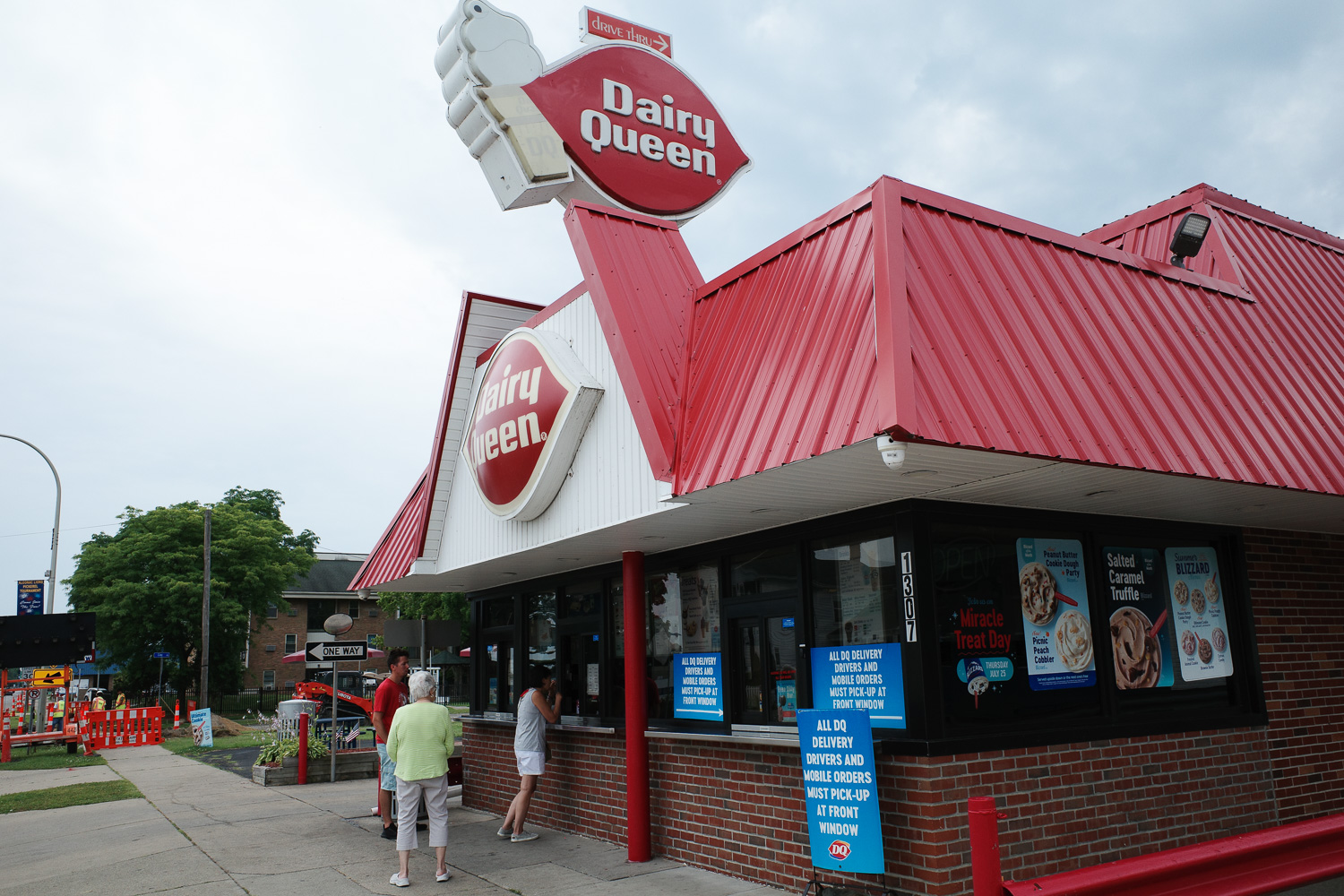 People standing in line at outdoor Dairy Queen.