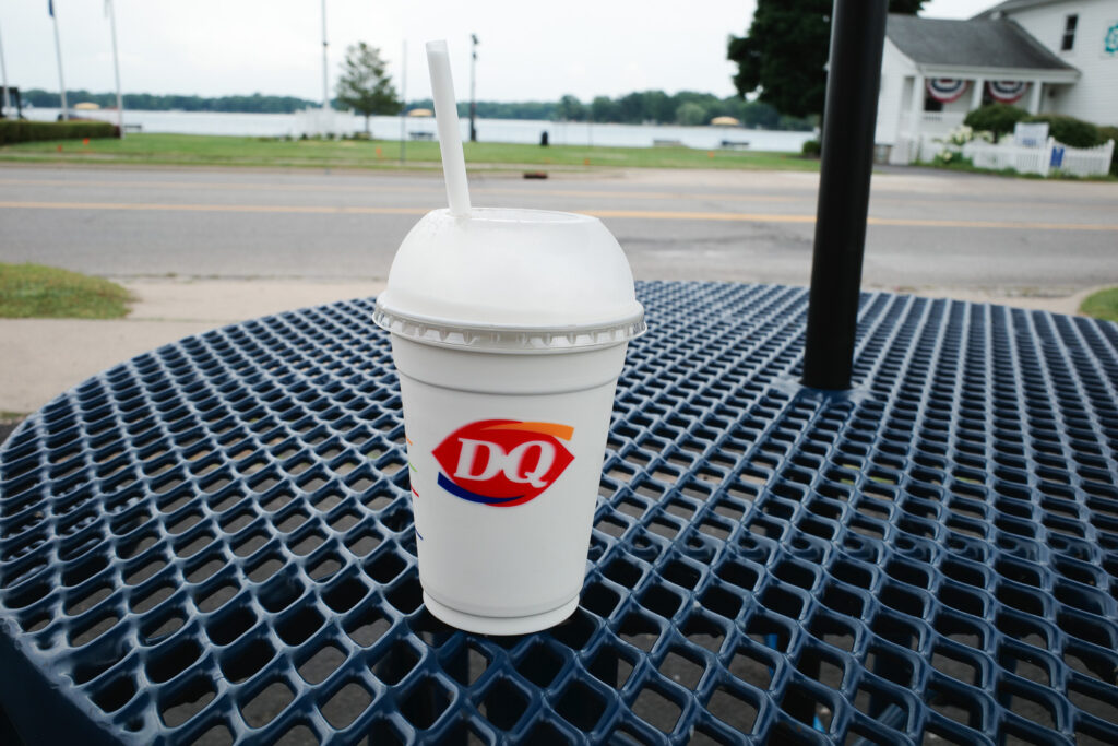 Dairy Queen vanilla milkshake on outdoor table.