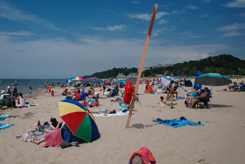 A view of crowded beach with colored umbrellas.