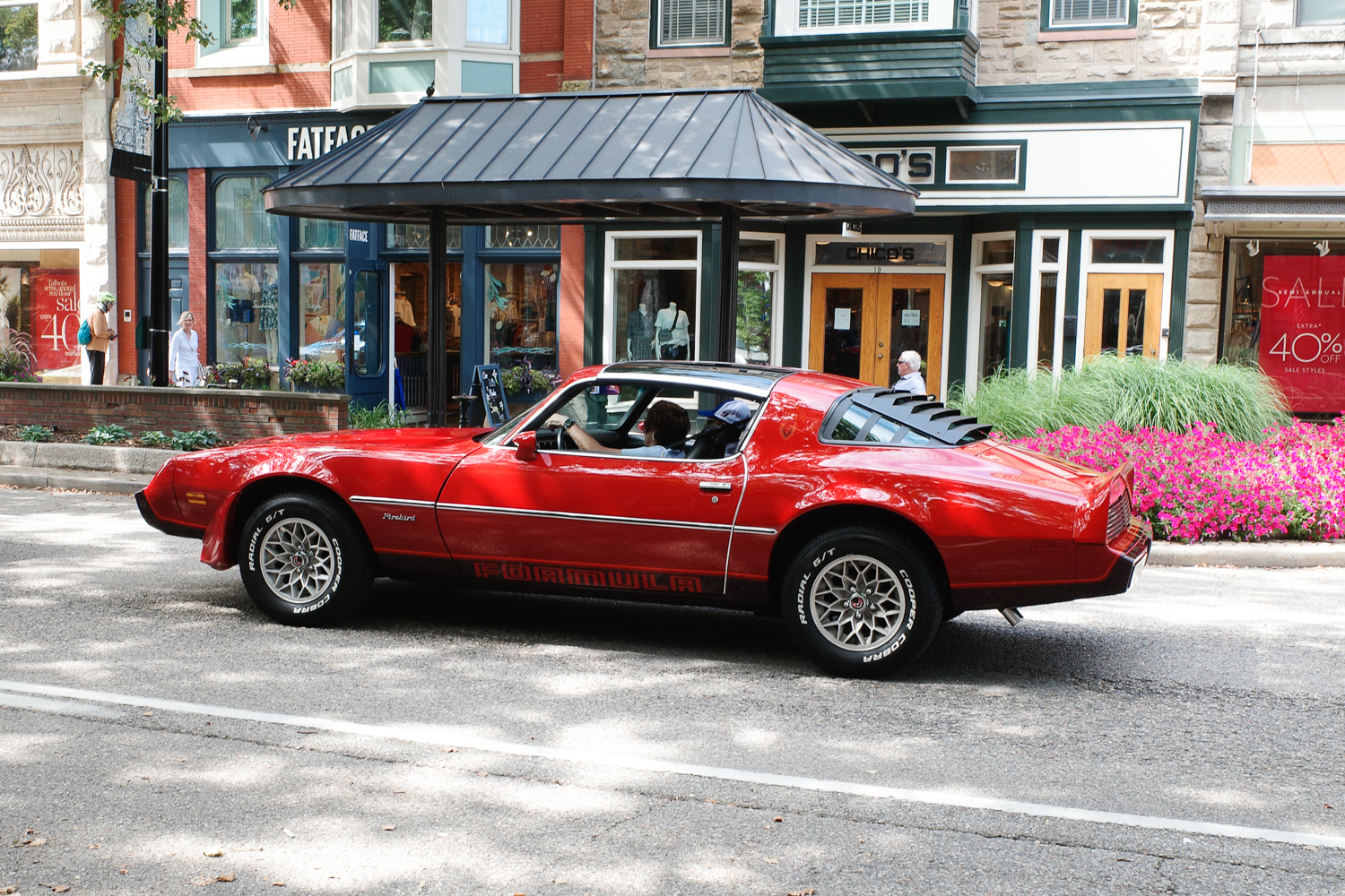 A red Pontiac Firebird on street.