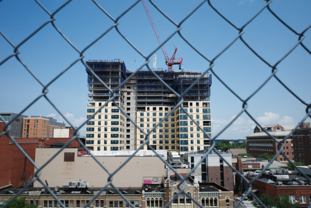 High rise construction in Ann Arbor viewed through chain link fence.