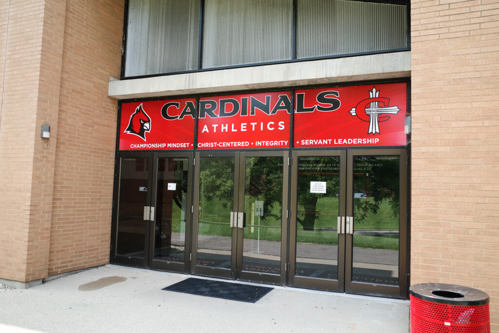 Entrance to Concordia Ann Arbor Athletics building with sign reading "Cardinals Athletics. Championship Mindset. Christ-Centered. Integrity. Servant Leadership."