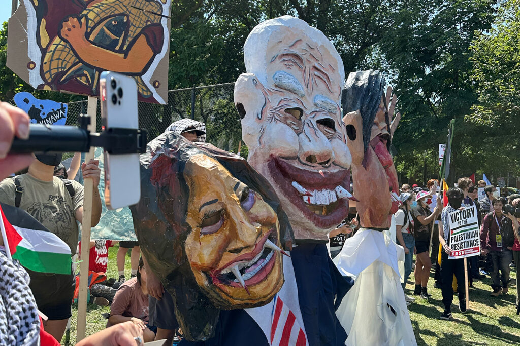 Caricature masks of Joe Biden and Kamala Harris with fangs dripping blood.