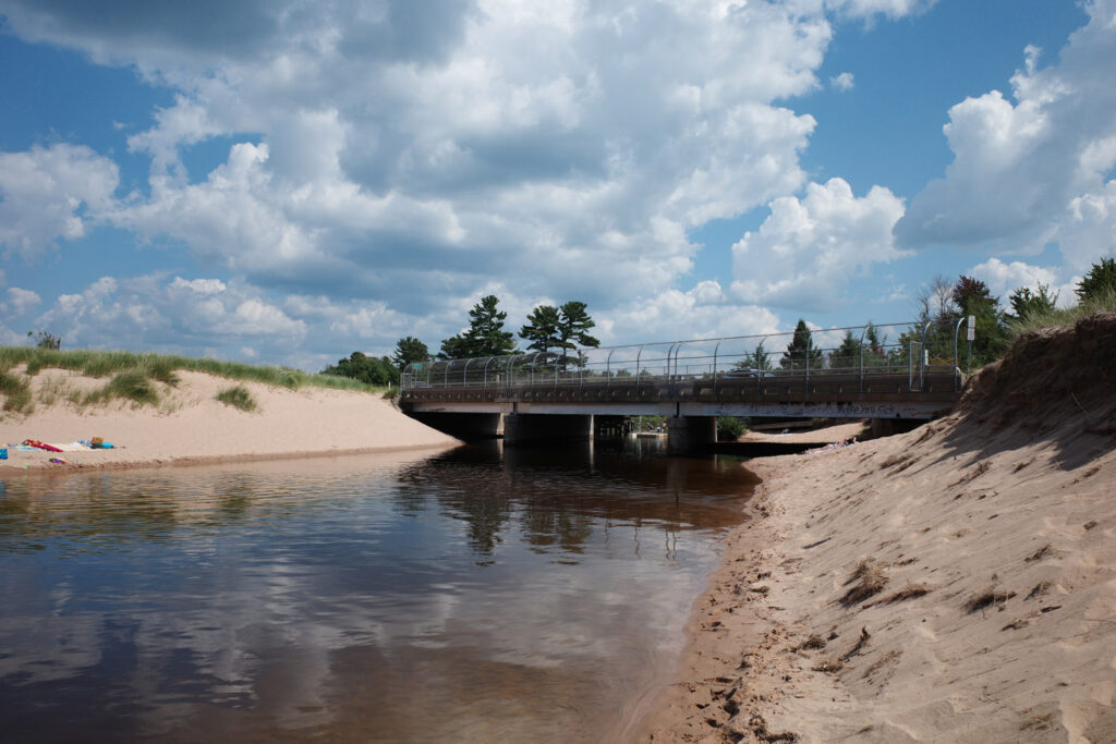 Bridge over small river with chainlink fence over sides.