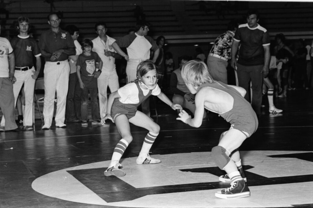 Tricia as a little girl in 1975 in a wrestling match with a boy.