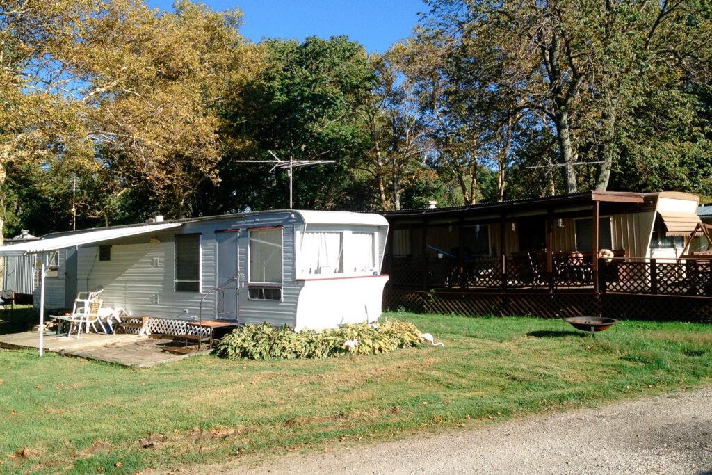 Two trailers on sunny day in trailer park.