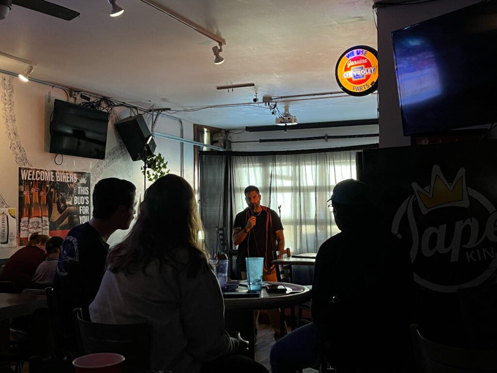 Man performing for crowd at comedy club.