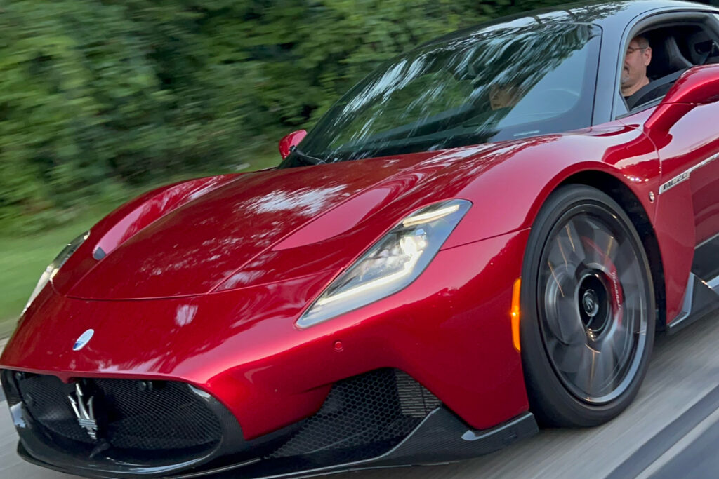 Maserati driving down road in motion.