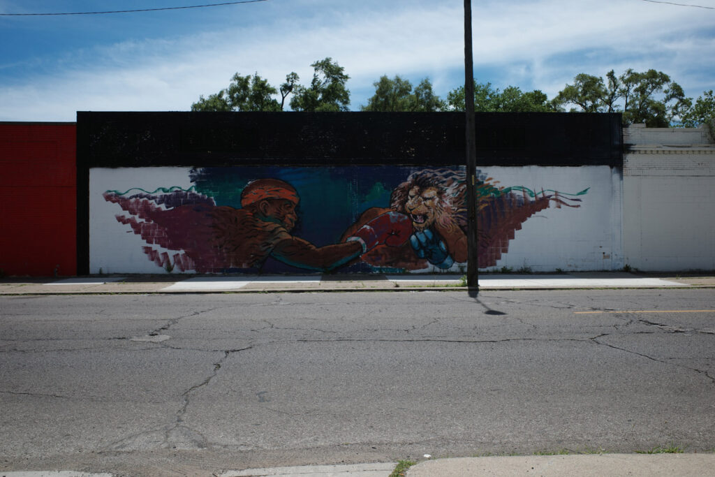 Mural of african american man punching a lion with boxing gloves on.