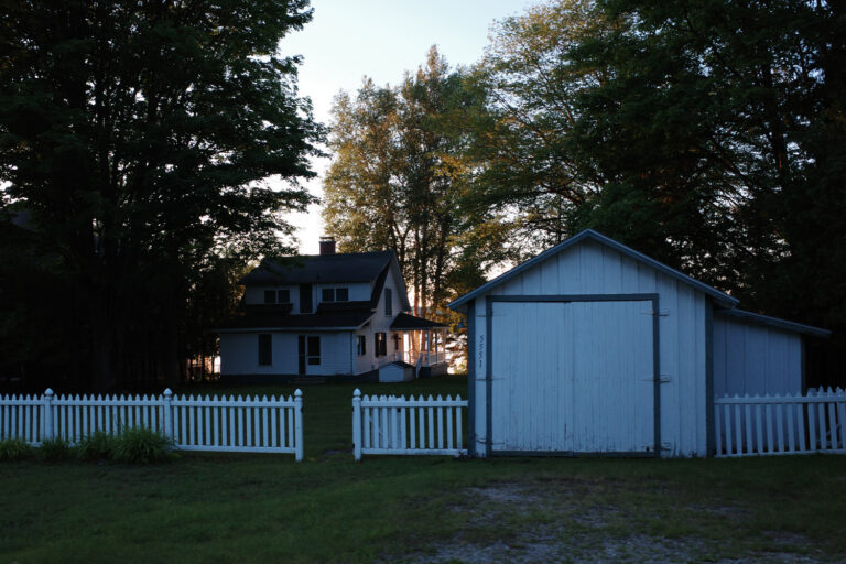 Cottage near lake at dusk.