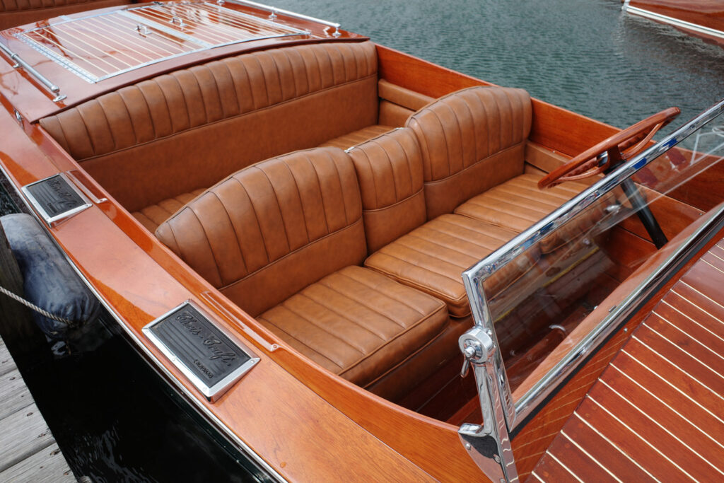 Wooden boat interior with brown leather seats.