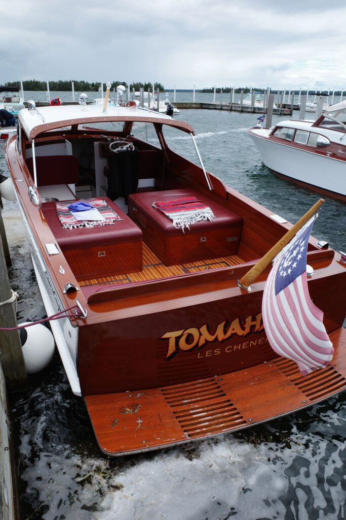 Wooden boat "Tomahawk" with american flag on back.