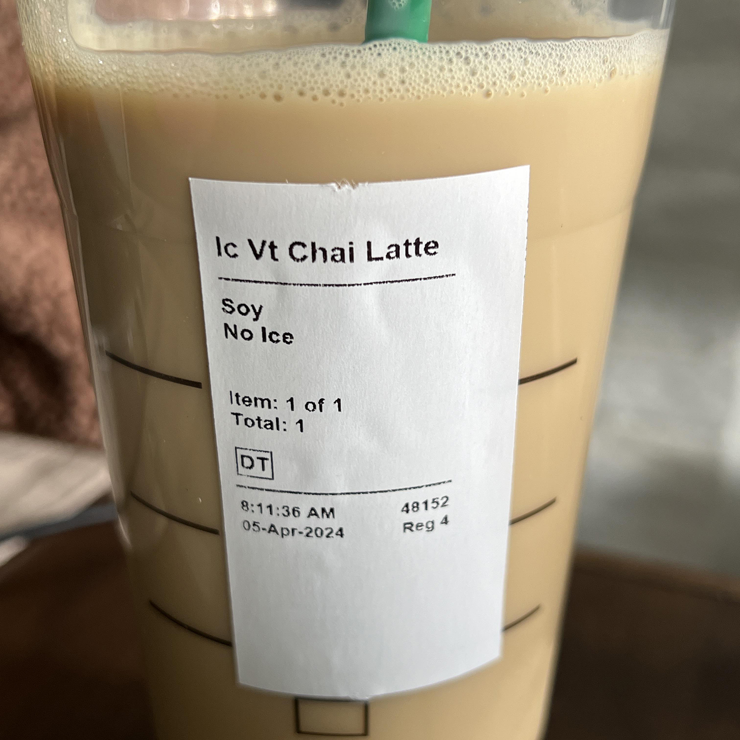 Iced chai latte with receipt reading "soy no ice" on cup.