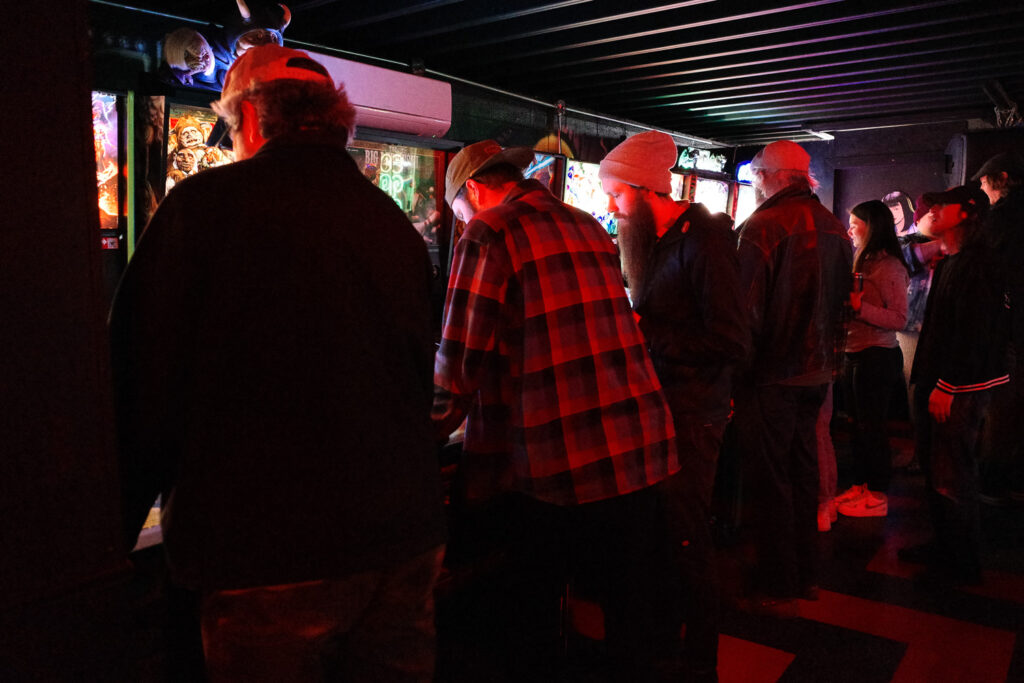 People playing pinball at the Coin Slot.