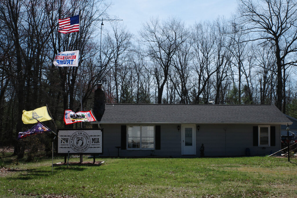 Roadside flag display outside house.