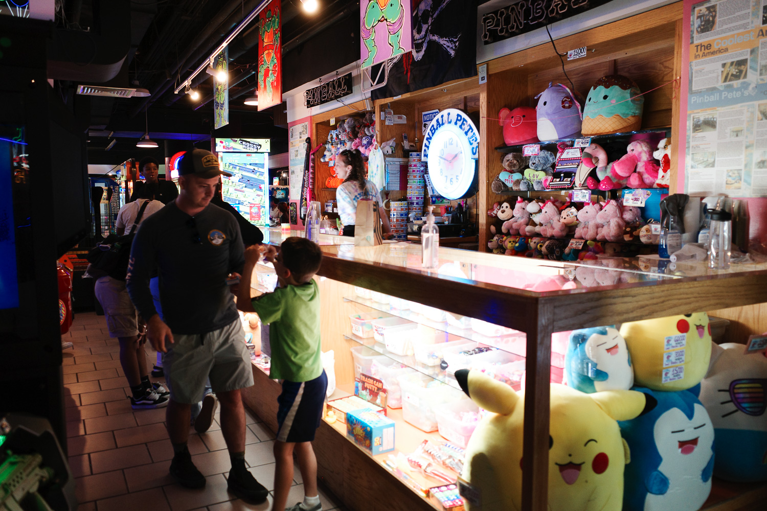 Arcade prize counter with man and boy smiling.