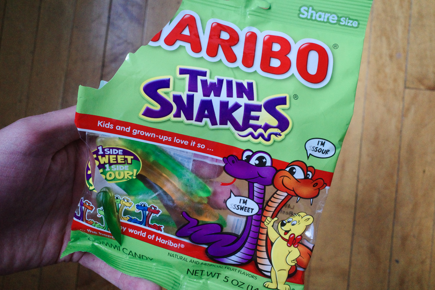 Opened pack of Haribo Twin Snakes in a man's hand.