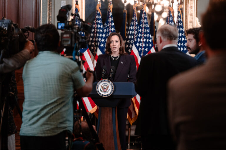 Kamala Harris speaking to reporters from podium.