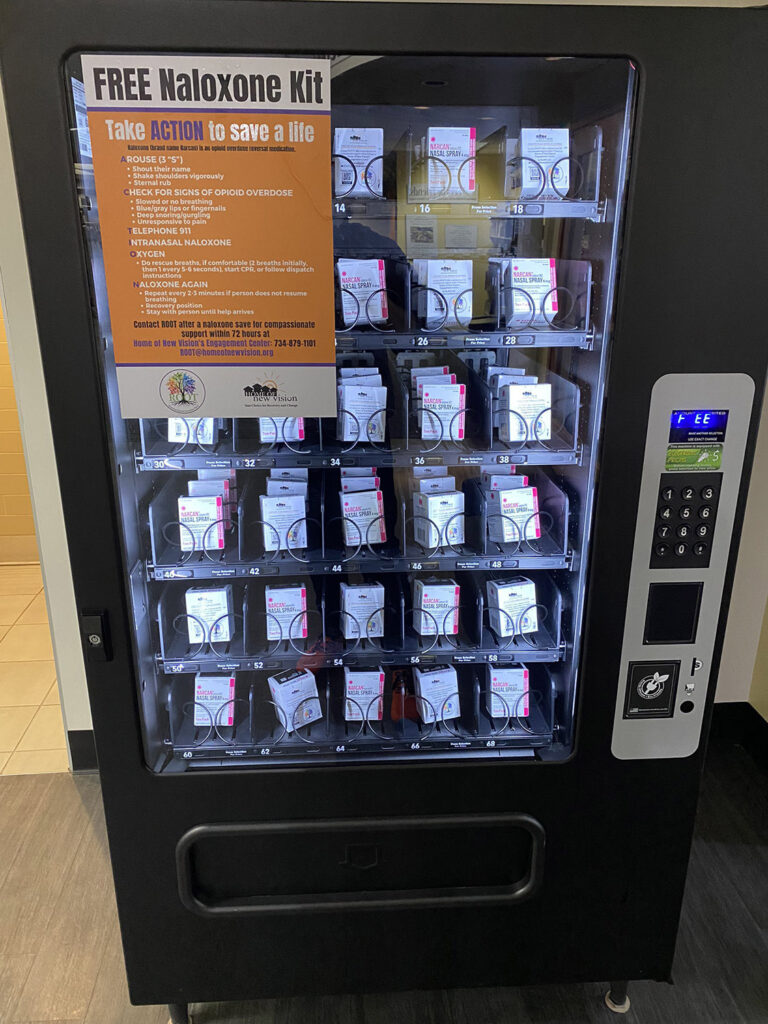 Narcan vending machine with text reading "Free Naloxone Kit" and "Take Action to Save A Life"