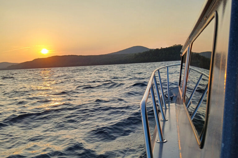 Boat on water at sunset.