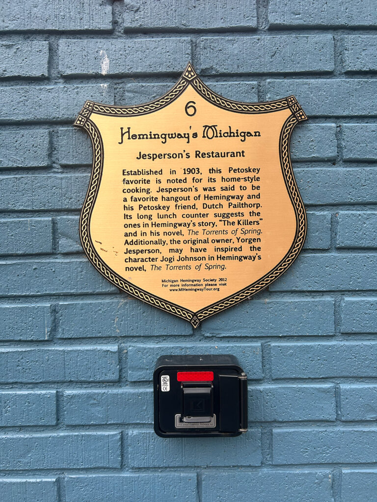 Sign reading, "Hemingway's Michigan
Jesperson's Restaurant
Established in 1903, this Petoskey favorite is noted for its home-style cooking. Jesperson's was said to be a favorite hangout of Hemingway and his Petoskey friend, Dutch Pailthorp. Its long lunch counter suggests the ones in Hemingway's story, "The Killers" and in his novel, The Torrents of Spring. Additionally, the original owner, Yorgen Jesperson, may have inspired the character Jogi Johnson in Hemingway's novel, The Torrents of Spring.
Michigan Hemingway Society 2012 For more information please visit www.MIHemingwayTour.org
"