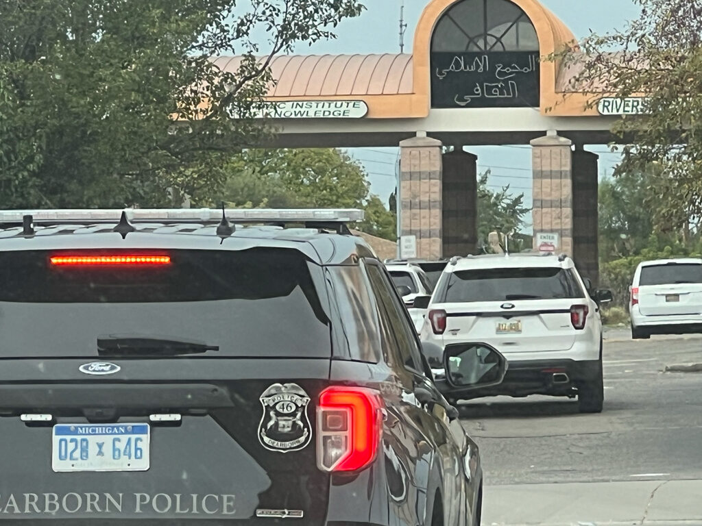 Dearborn police car outside traffic entering Islamic Institute of Knowledge.