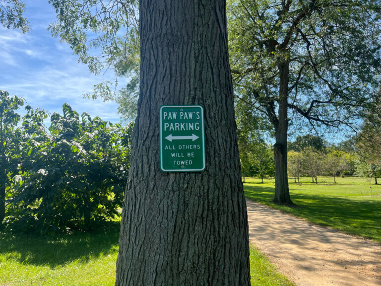 Sign in orchard reading "PAW PAW'S PARKING ALL OTHERS WILL BE TOWED"