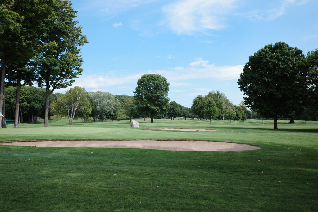 View of bunkers and stone obelisk on golf course.