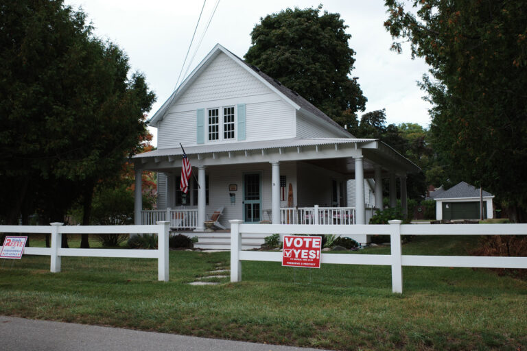 Home in Harbor Springs with American flag and red sign reading "vote yes to repeal ord. 439"