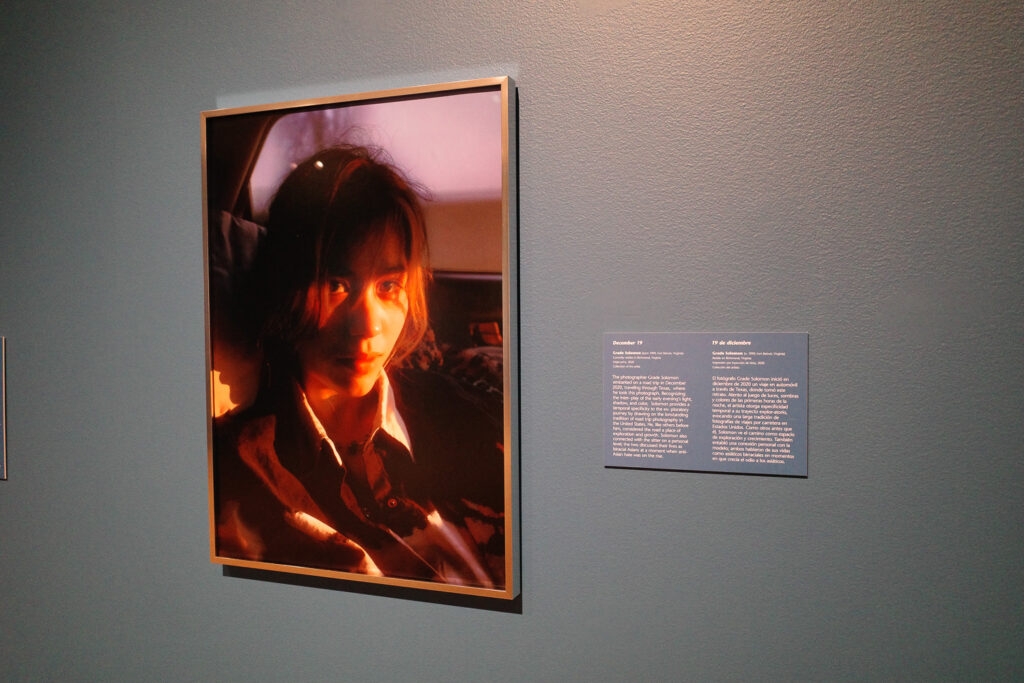 Photograph of a half-asian woman with golden light across her face, wall text next to it.