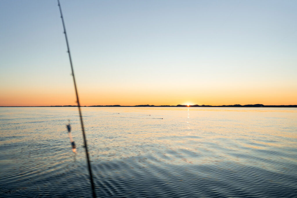 Reel in foreground looking over sunset at large lake.