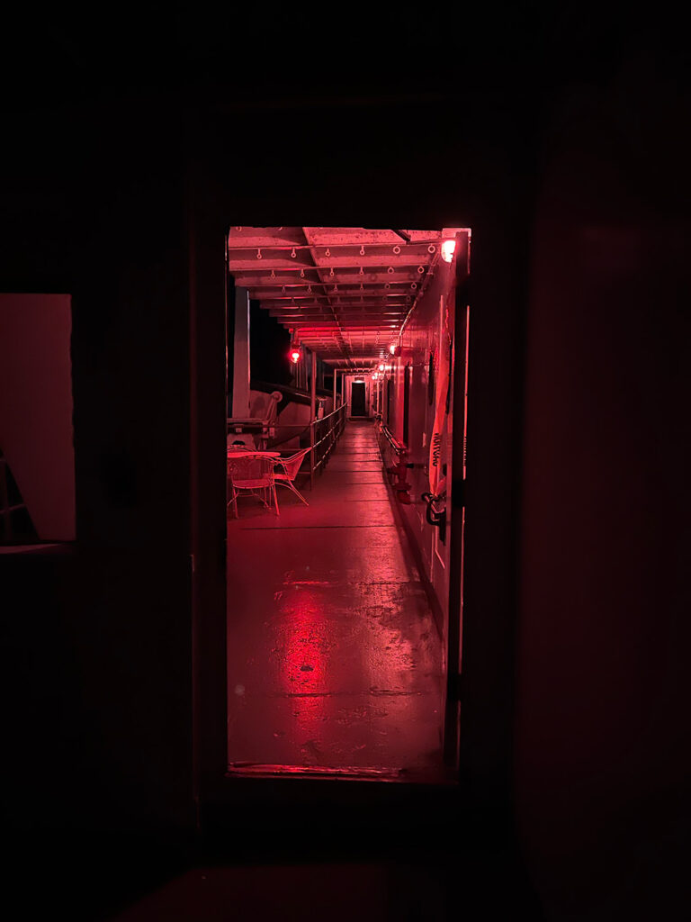 View down ship's hallway at night lit red