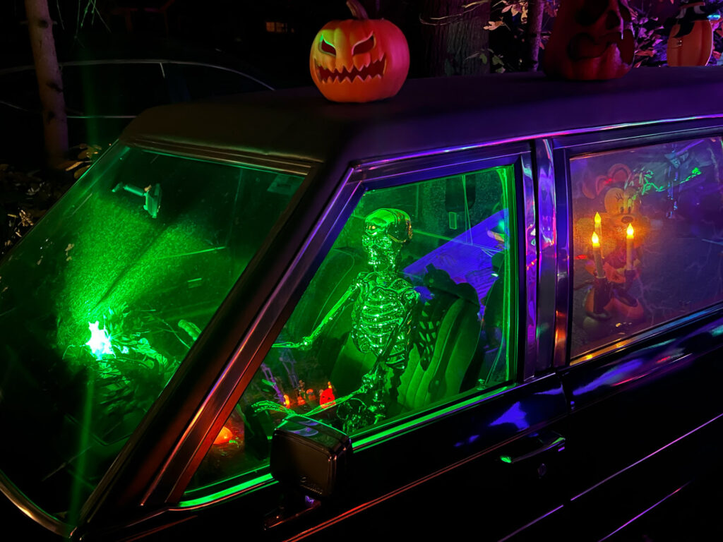 Skeleton lit up green in driver's seat of hearse