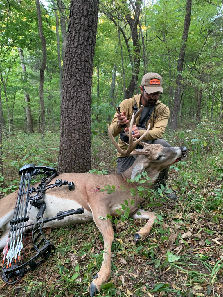 Hunter with crossbow and dead buck.