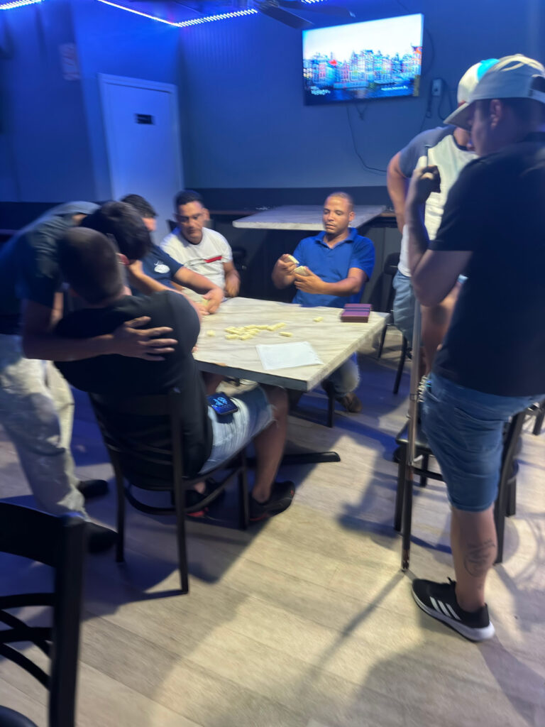 Men inside bar playing dominos.