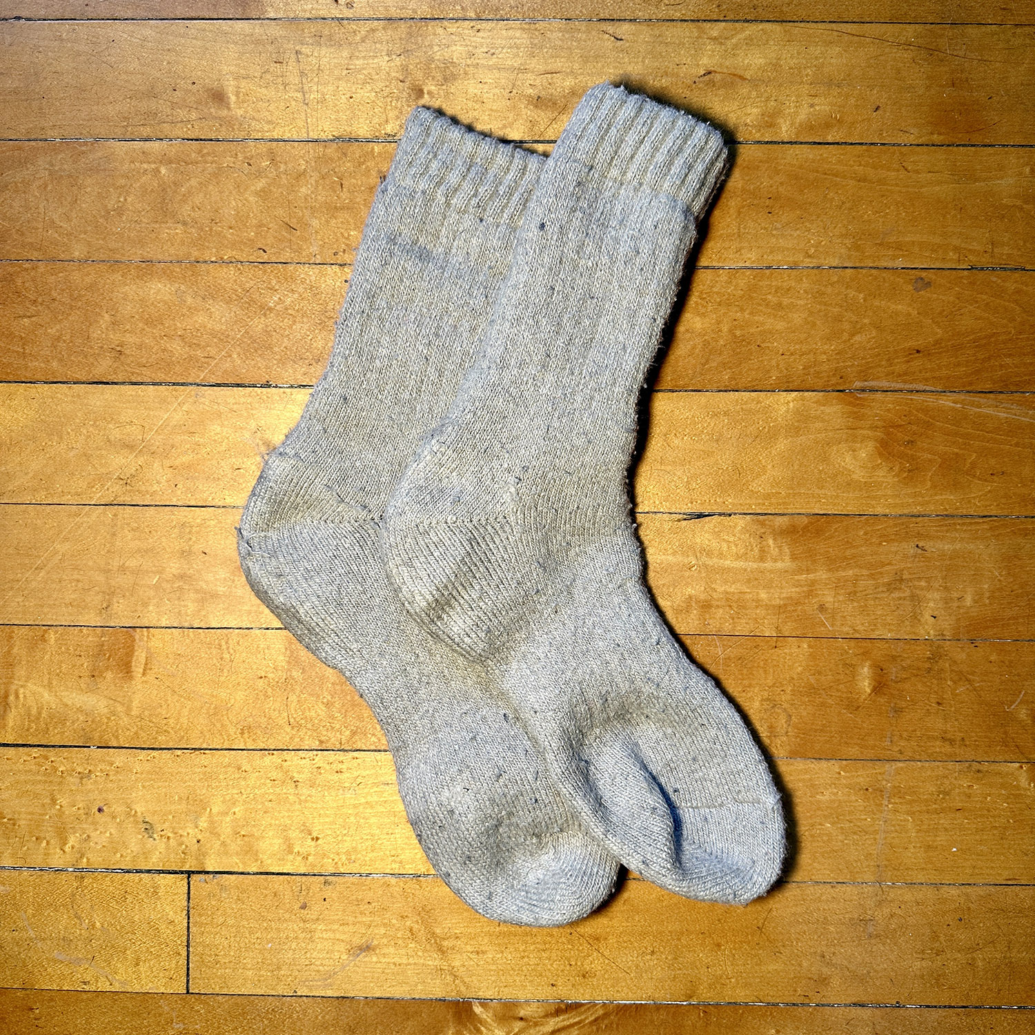 Tan wool socks on hardwood floor.