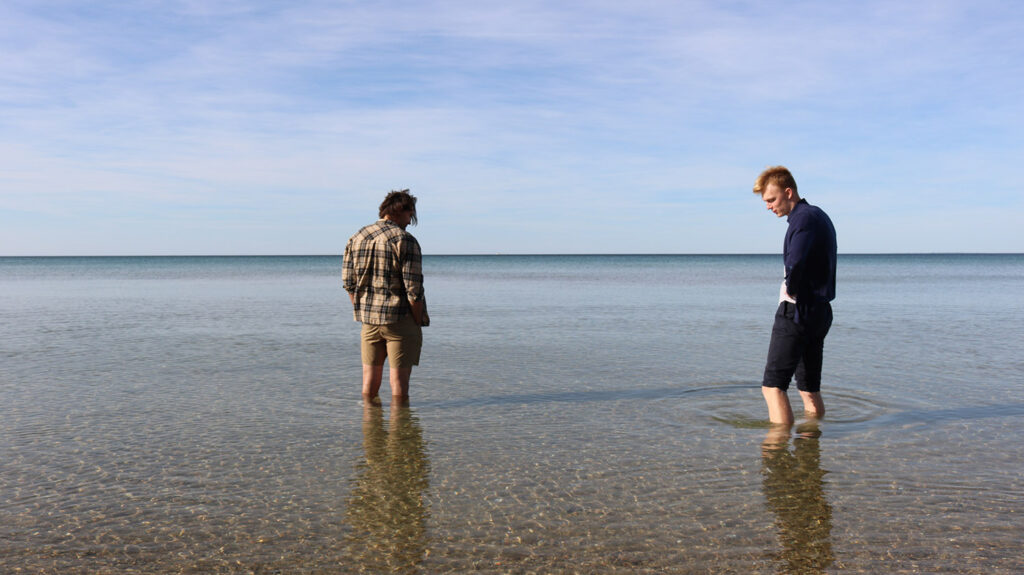 Two men standing in lake