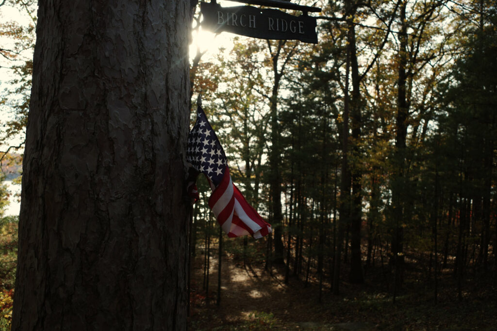 American flag and sign for "Birch Ridge" in woods