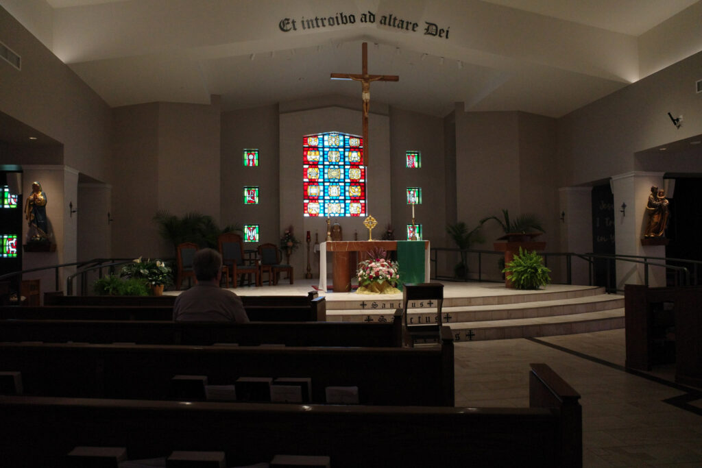 Inside of church with scrip on wall reading "Et Introibo ad altare Dei"