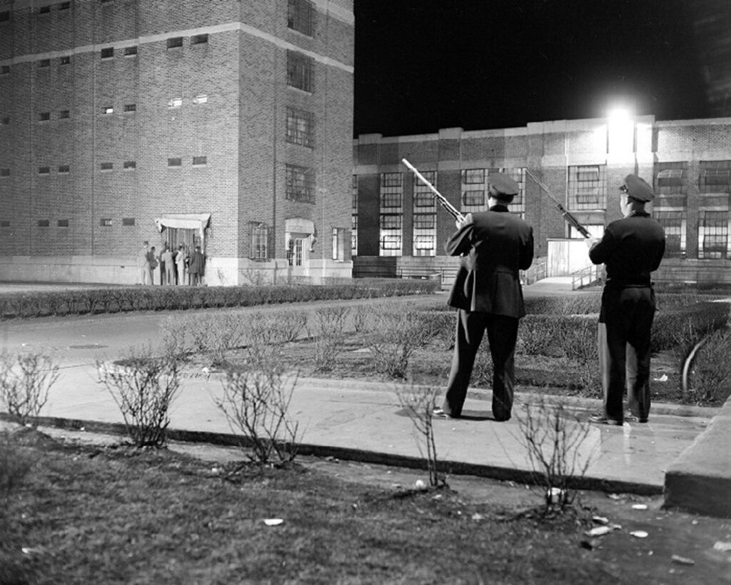 Prison guards with rifles outside prison