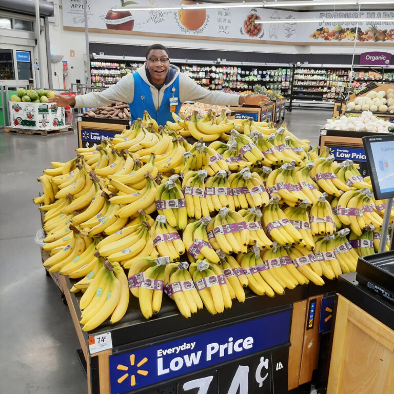 Walmart employee with pile of bananas